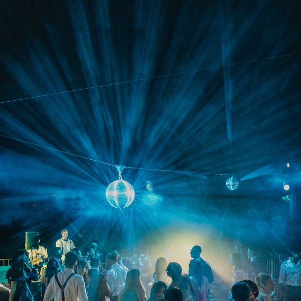 A disco ball over a wedding after-party dance floor.