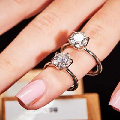 Finger wearing two lab grown diamond solitaire rings