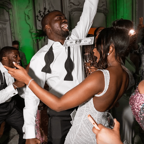 couple dancing and spraying money at their wedding reception